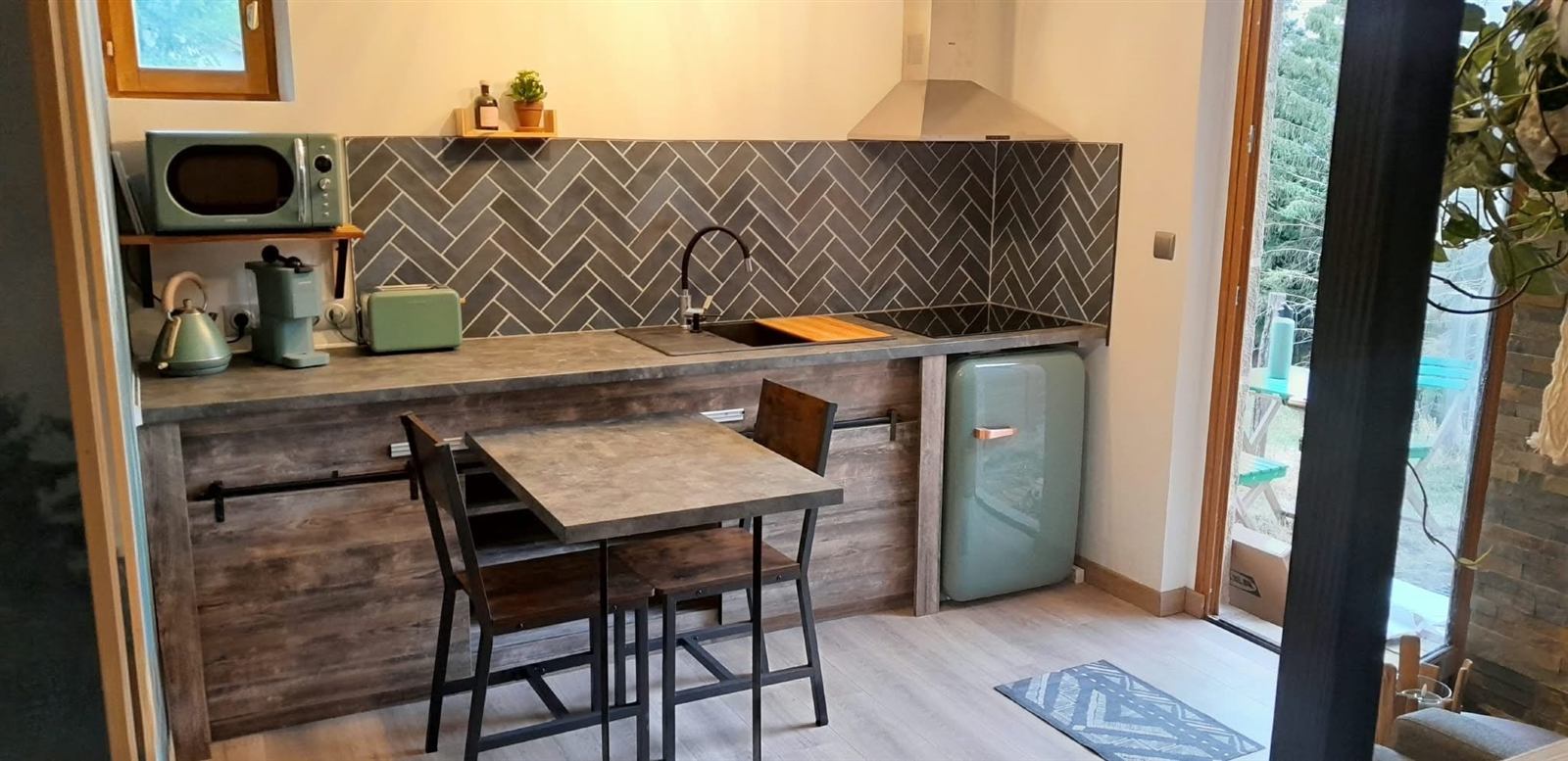 Petite cuisine aménagée avec plan de travail et crédence